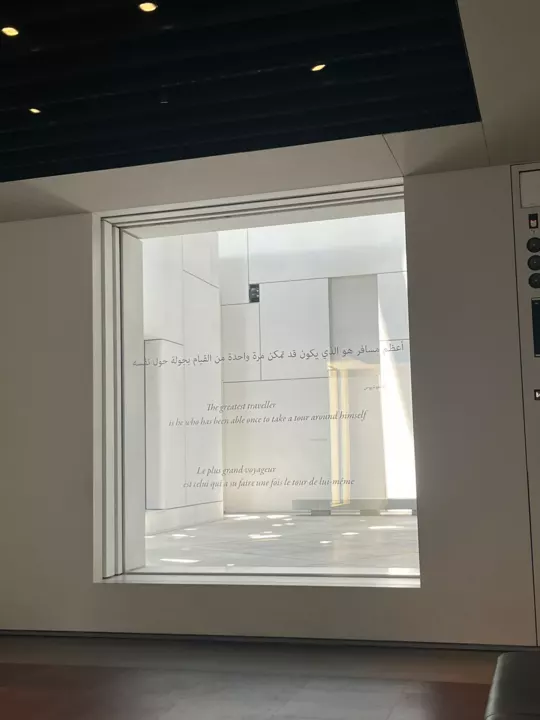 A museum window bearing a quotation attributed to Confucius in Arabic, English and French.